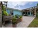 Inviting outdoor patio featuring a charming pergola, lush greenery, planters, and comfortable seating arrangements at 775 Bay Dr, New Smyrna Beach, FL 32168