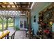 Charming outdoor patio featuring a pergola, potted plants, seating, and a decorative clock creating a relaxing ambiance at 775 Bay Dr, New Smyrna Beach, FL 32168
