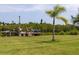 Expansive backyard showcasing a wooden dock and waterside access, framed by a mature palm tree and a lush green lawn at 775 Bay Dr, New Smyrna Beach, FL 32168