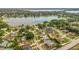 Panoramic aerial view of a lakeside community showcasing houses with pools, lush trees and a serene lake at 8134 Hook Cir, Orlando, FL 32836