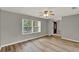 Inviting living area featuring stylish wood-look flooring, a ceiling fan, and a large window for ample natural light at 840 Baybreeze Ln, Altamonte Springs, FL 32714