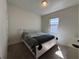 Comfortable bedroom featuring a white frame bed, carpet flooring, and natural light from the window at 8930 Zurich Ln, Kissimmee, FL 34747