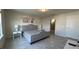 Comfortable bedroom featuring a gray upholstered bed, tile flooring, and neutral-toned walls at 8930 Zurich Ln, Kissimmee, FL 34747