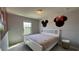Bright bedroom featuring a white frame bed, tile flooring, and playful decor on the walls at 8930 Zurich Ln, Kissimmee, FL 34747