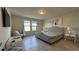 Well-lit main bedroom featuring a gray upholstered bed, tile flooring, and neutral-toned walls at 8930 Zurich Ln, Kissimmee, FL 34747