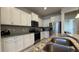 Modern kitchen with white cabinetry, stainless steel appliances, granite countertops, and a stainless steel sink at 8930 Zurich Ln, Kissimmee, FL 34747