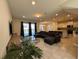 Spacious living room featuring a comfortable sectional sofa, large windows, and an open layout to the kitchen at 8930 Zurich Ln, Kissimmee, FL 34747