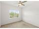 Carpeted bedroom with a ceiling fan and large window with backyard view at 9425 Holliston Creek Pl, Winter Garden, FL 34787