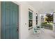 Charming front porch featuring a rocking chair and a vibrant blue front door at 9425 Holliston Creek Pl, Winter Garden, FL 34787