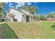A expansive lawn leads up to a screened in porch and two trash receptacles at 9616 River Walk Ct, Orlando, FL 32825