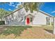 A backyard features a red back door, a screened porch, and green grass at 9616 River Walk Ct, Orlando, FL 32825