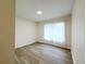 Bedroom showcasing wood-look floors, a large window with light curtains, and a neutral color palette at 965 Brentwood Dr, Apopka, FL 32712