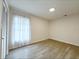 Airy bedroom features wood-look floors, a bright window with sheer curtains, and fresh, neutral decor at 965 Brentwood Dr, Apopka, FL 32712