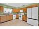 Bright kitchen features wood cabinetry, white appliances, and neutral tile flooring at 969 Gran Paseo Dr, Orlando, FL 32825