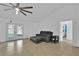 Bright living room features neutral tile flooring, ceiling fan, and sliding glass doors at 969 Gran Paseo Dr, Orlando, FL 32825