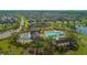Aerial view of community pool, amenity center, and surrounding neighborhood with lush landscaping and beautiful homes at 10520 Burrows St, Orlando, FL 32832
