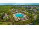 Aerial view of community pool with palm trees, pergolas, and plenty of seating at 10520 Burrows St, Orlando, FL 32832