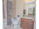 Well-lit bathroom featuring a tub with shower, granite vanity, and coordinated decor at 10520 Burrows St, Orlando, FL 32832
