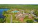 Aerial view of resort-style pool with clubhouse, palm trees, and lake views at 10520 Burrows St, Orlando, FL 32832