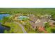 Aerial view of resort-style pool with clubhouse, palm trees, and lake views at 10520 Burrows St, Orlando, FL 32832