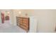 Inviting hallway featuring a wooden dresser with drawers, a decorative flower arrangement, and neutral colored walls at 10520 Burrows St, Orlando, FL 32832
