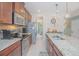 Modern kitchen with granite countertops, stainless steel appliances, and center island featuring a sink at 10520 Burrows St, Orlando, FL 32832