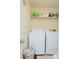 Efficient laundry room featuring white appliances, convenient shelving, and a practical basket for sorting at 10520 Burrows St, Orlando, FL 32832