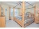 Spacious main bedroom boasts a tray ceiling, neutral carpet, and a stately four-poster bed at 10520 Burrows St, Orlando, FL 32832