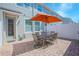 Relaxing outdoor patio with brick pavers, a dining table, and an orange umbrella for shade at 10520 Burrows St, Orlando, FL 32832