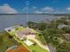 Stunning aerial view of a lakefront property with a private dock, basketball court, and beautifully landscaped grounds at 10845 Bayshore Dr, Windermere, FL 34786