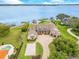 Stunning waterfront home with lush landscaping, private dock, and basketball court offer the ultimate in luxury living at 10845 Bayshore Dr, Windermere, FL 34786