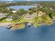 Breathtaking aerial shot of an estate on the lake, featuring private dock, boat lift, pool, and lush landscaping at 10845 Bayshore Dr, Windermere, FL 34786