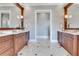 Elegant bathroom featuring dual vanities with marble countertops and decorative mirrors in a neutral color palette at 10845 Bayshore Dr, Windermere, FL 34786
