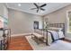 Neutral bedroom featuring hardwood floors, ceiling fan, and a wrought iron bed at 10845 Bayshore Dr, Windermere, FL 34786