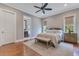 A serene bedroom with hardwood floors, a ceiling fan, and a comfortable bed at 10845 Bayshore Dr, Windermere, FL 34786