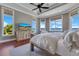 Inviting bedroom with lake views, tray ceilings, ceiling fan, and large windows for natural light at 10845 Bayshore Dr, Windermere, FL 34786