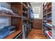 Walk-in closet with custom wood shelving, drawers, and a window for natural light at 10845 Bayshore Dr, Windermere, FL 34786