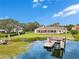 Picturesque view of a private boat dock on the water, complemented by the stunning home and lush landscaping at 10845 Bayshore Dr, Windermere, FL 34786