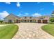 Beautiful front exterior with circular driveway, meticulous landscaping, and a three-car garage at 10845 Bayshore Dr, Windermere, FL 34786