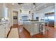 Open concept kitchen with large island, custom cabinets, wood flooring, stainless appliances, and granite countertops at 10845 Bayshore Dr, Windermere, FL 34786