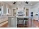 Kitchen featuring large island with seating, stainless appliances, custom cabinets, granite countertops, and wood flooring at 10845 Bayshore Dr, Windermere, FL 34786