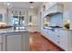 Gourmet kitchen with stainless steel appliances, granite countertops, custom cabinets, and wood flooring at 10845 Bayshore Dr, Windermere, FL 34786