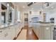 Eat-in kitchen with farm sink, wood floors, granite counters, custom cabinets, tile backsplash, and water view at 10845 Bayshore Dr, Windermere, FL 34786