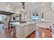 Bright eat-in kitchen features wood floors, oversized island, granite counters, custom cabinets, and water view at 10845 Bayshore Dr, Windermere, FL 34786