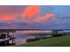 Breathtaking lake view at sunset from the lush green lawn with dock at 10845 Bayshore Dr, Windermere, FL 34786