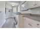 Bright laundry room with granite countertop, cabinets, washer, and dryer at 10845 Bayshore Dr, Windermere, FL 34786