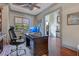 Stylish home office with wood floors, tray ceiling, windows, and a large desk with a modern chair at 10845 Bayshore Dr, Windermere, FL 34786