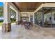 Inviting covered patio with an outdoor kitchen, stone pillars, and lake view at 10845 Bayshore Dr, Windermere, FL 34786
