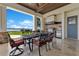 Covered outdoor patio featuring seating and a built-in kitchen with lake view at 10845 Bayshore Dr, Windermere, FL 34786