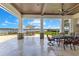Covered patio with outdoor seating, built-in grill, and stunning waterfront views at 10845 Bayshore Dr, Windermere, FL 34786